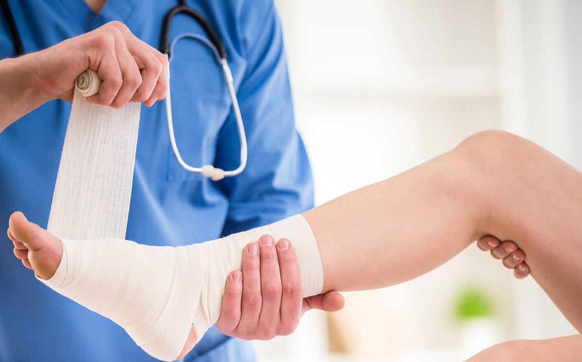 Medical provider examining patient's ankle injury