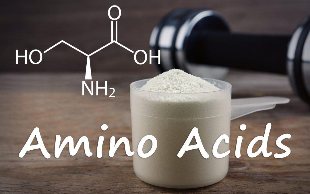 Measuring scoop of amino acids powder on wooden table