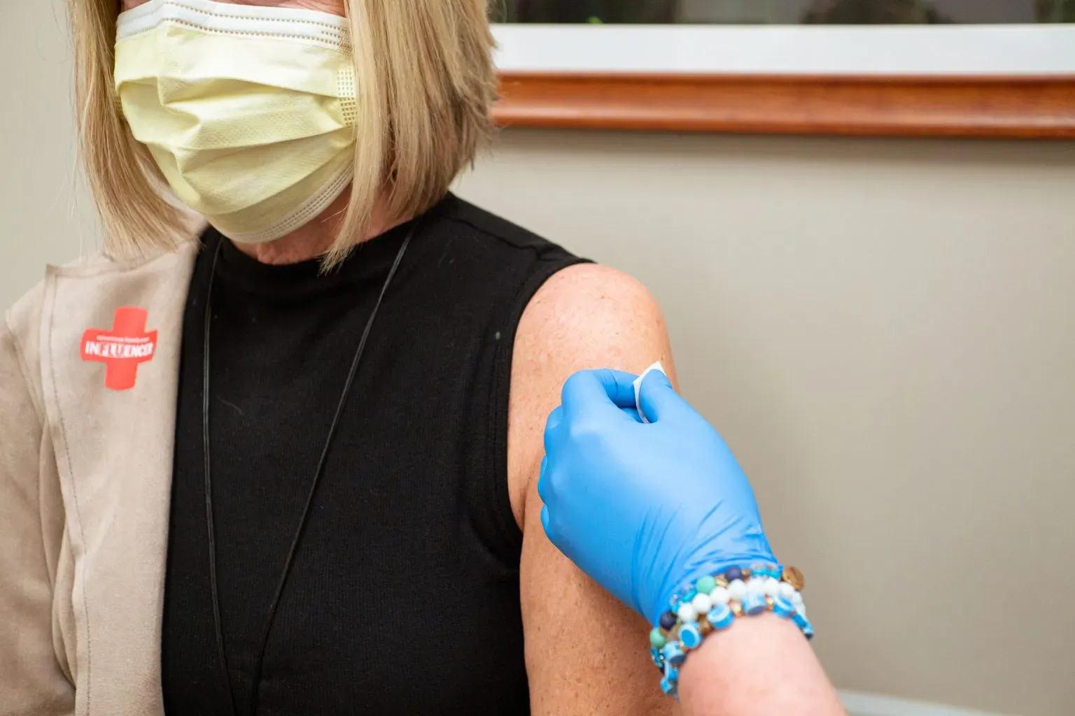 A patient being preped to be given a shot by a medical professional