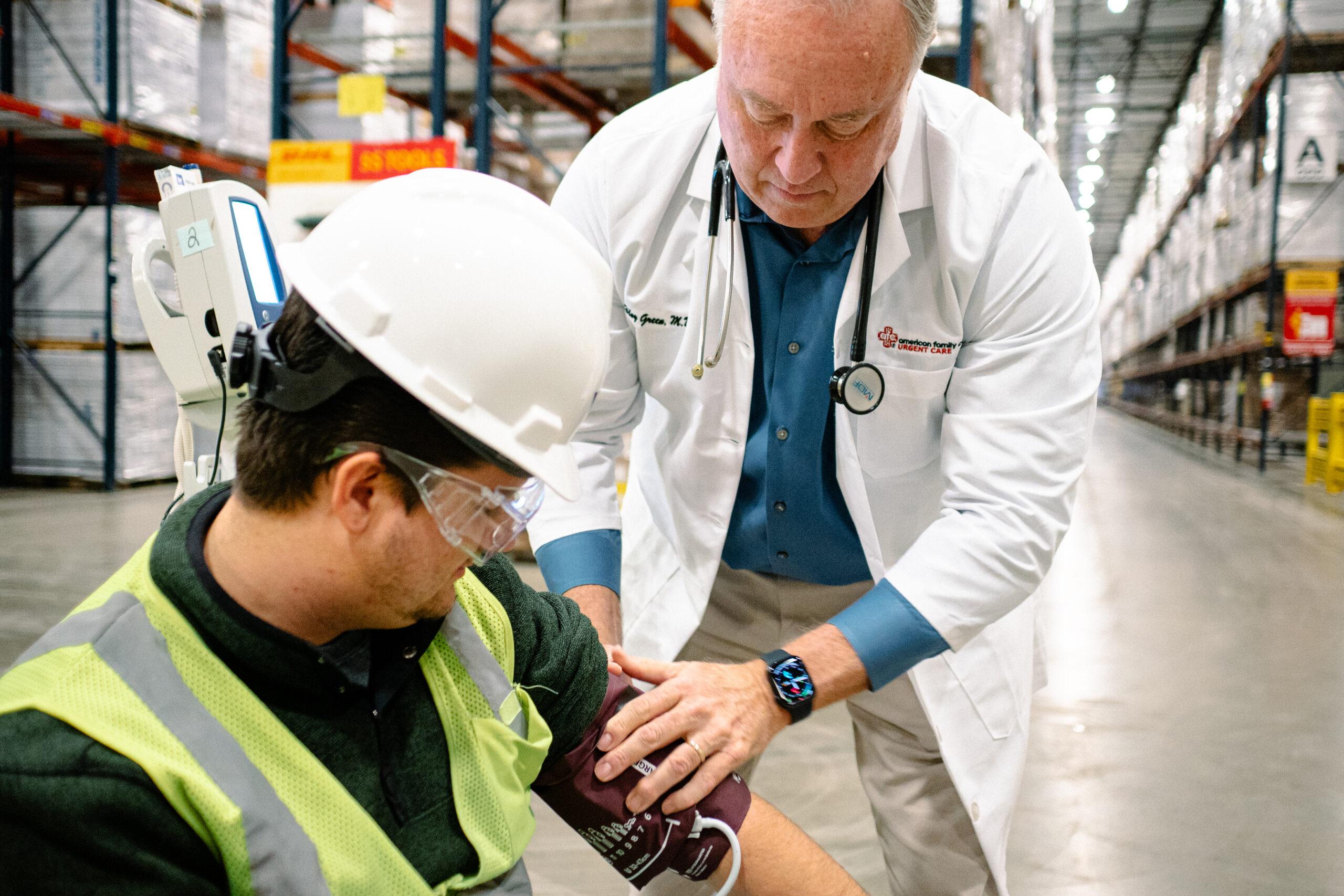 An AFC medical provider preparing to check a worker&rsquo;s blood pressure with a blood pressure cuff as part of a DOT physical examination. 