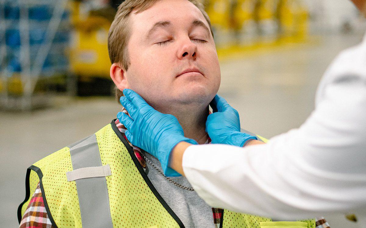medical provider checking potential employee's glands
