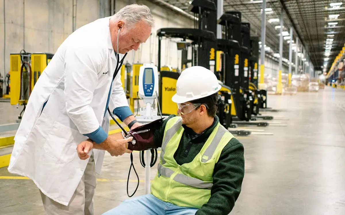 Male medical physician checking an emplyee's blood pressure