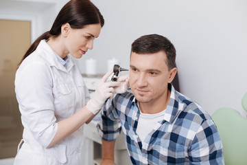 Man getting his ear checked for swimmer’s ear by a provider at AFC Urgent Care Saugus