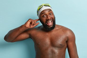 African American man noticing a pain in his ear and thinks it could be swimmer’s ear