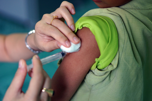 child receives flu shot in left arm