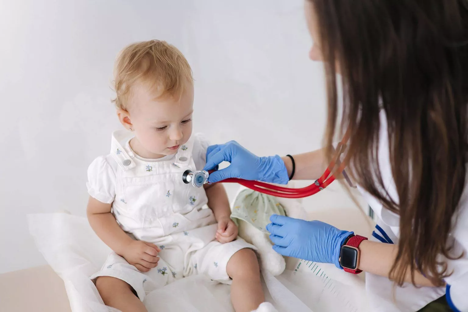 female doctor checking infant lungs urgent care