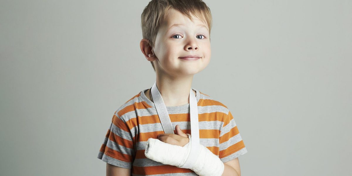 child smiling despite his broken arm