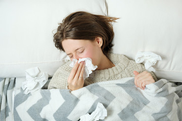 Woman sick in bed and is confused as to whether or not she has the flu or RSV