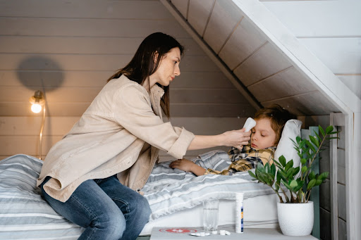 Mother tending to her sick daughter and realizing she may have the flu or RSV