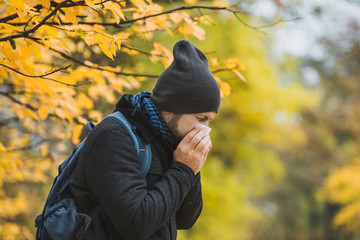 A man blowing his nose and on his way to AFC Urgent Care Saugus to see if he has RSV, the flu, or something else