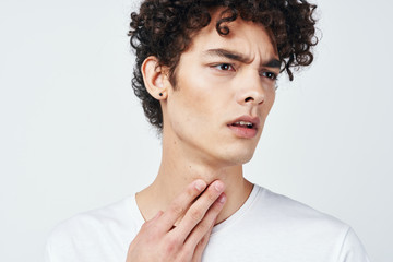 Man feeling his throat to see if he has Strep throat or COVID-19