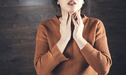 Woman holding onto her neck because she has Strep throat