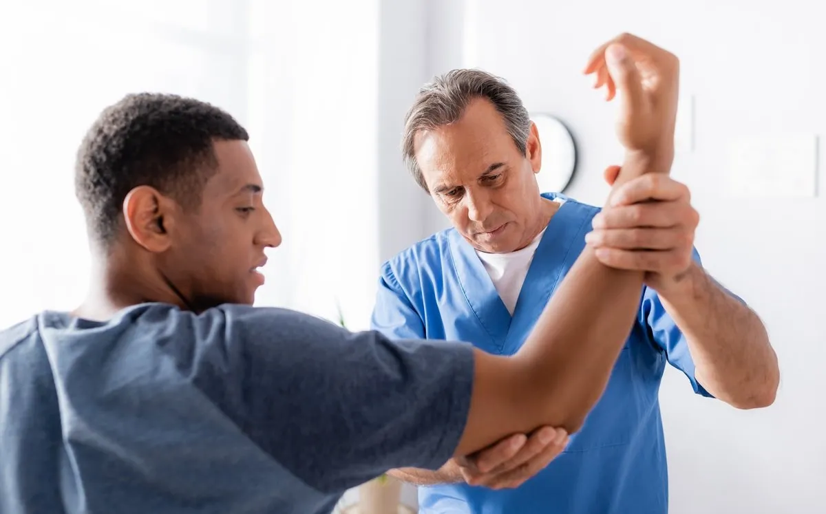 medical provider examining patient's elbow injury