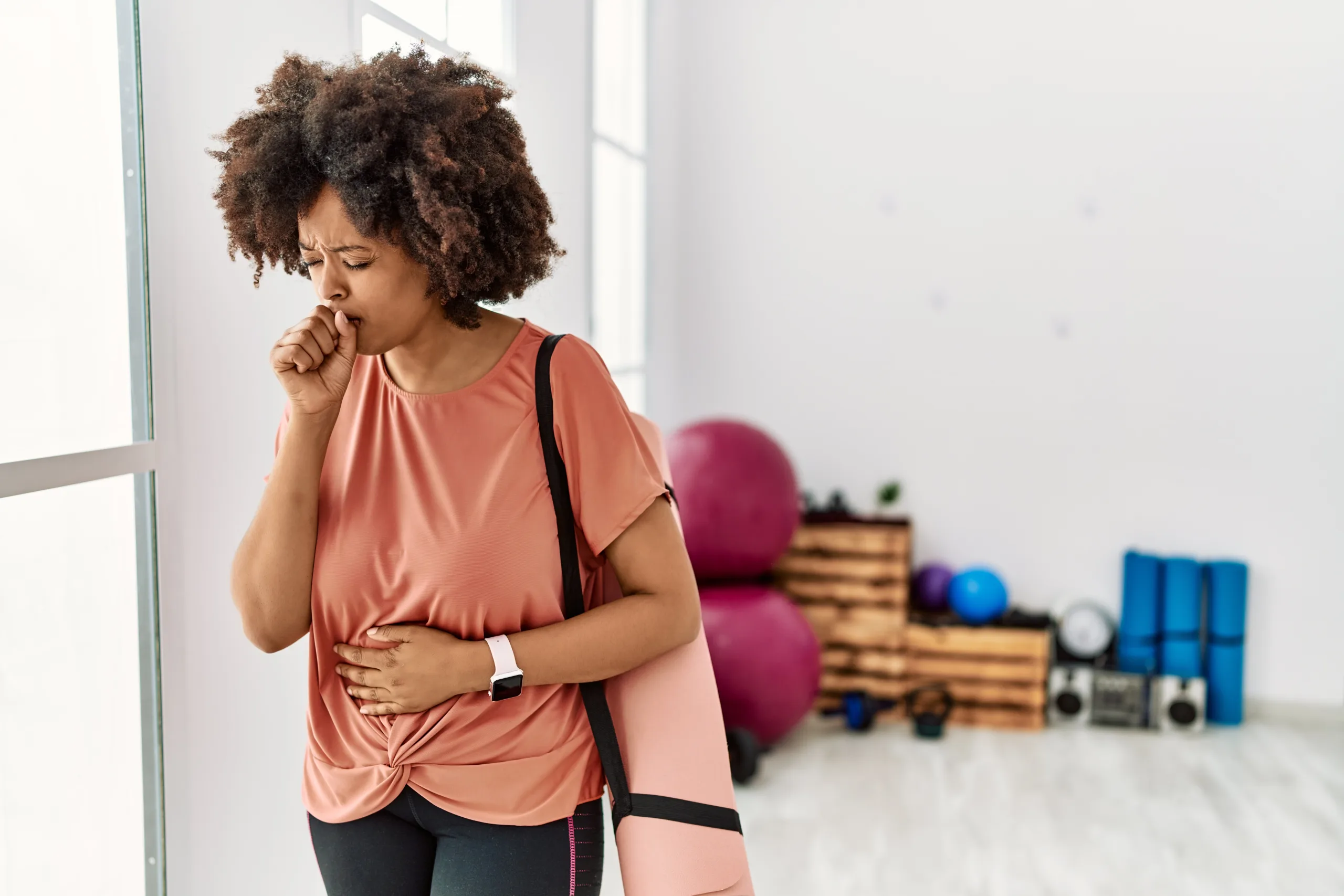 Woman coughing while leaving yoga class