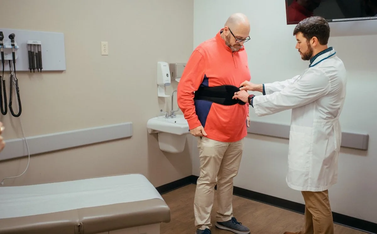 Medical provider fitting patient for a back brace