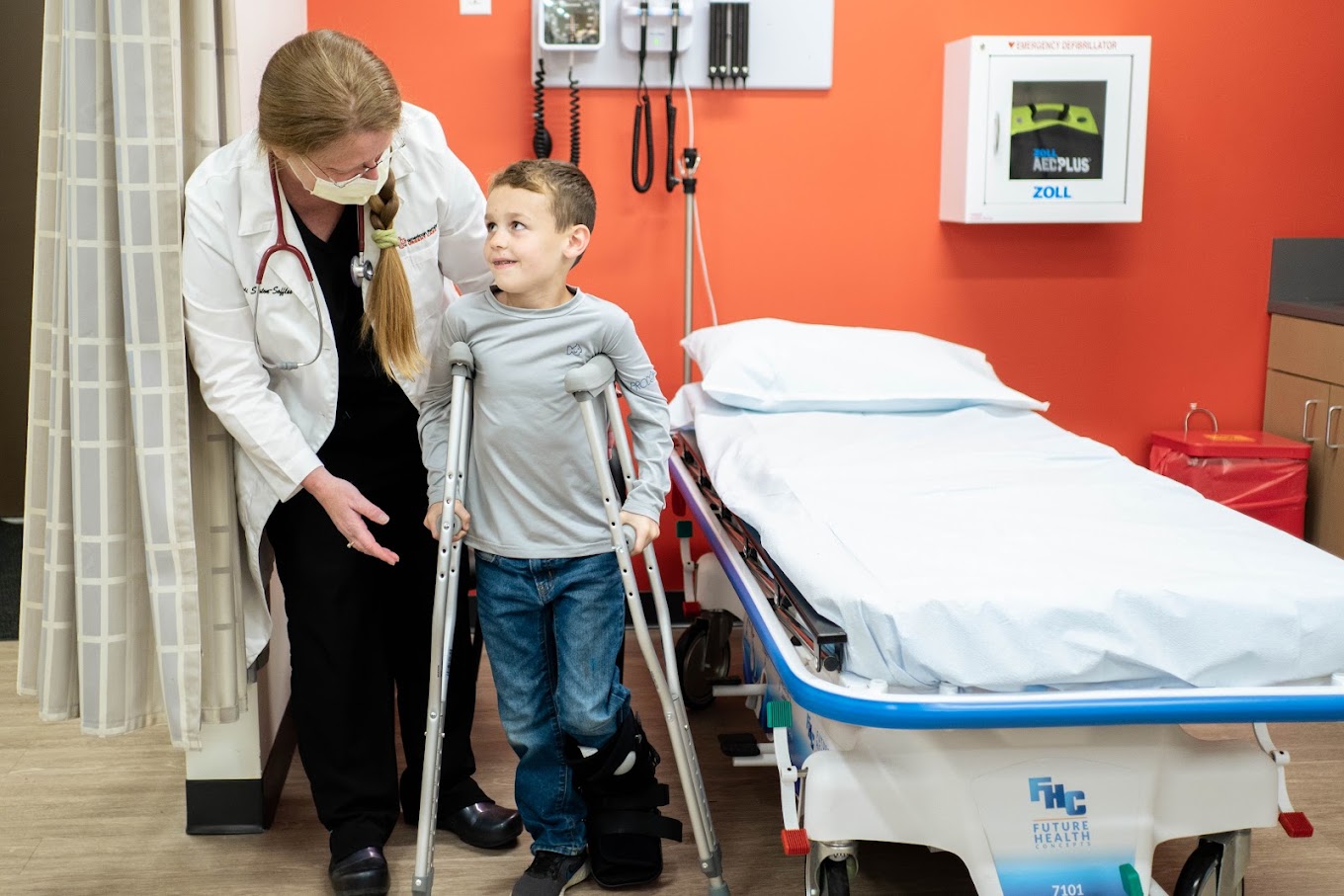 Young boy getting boot and crutches for ankle injury